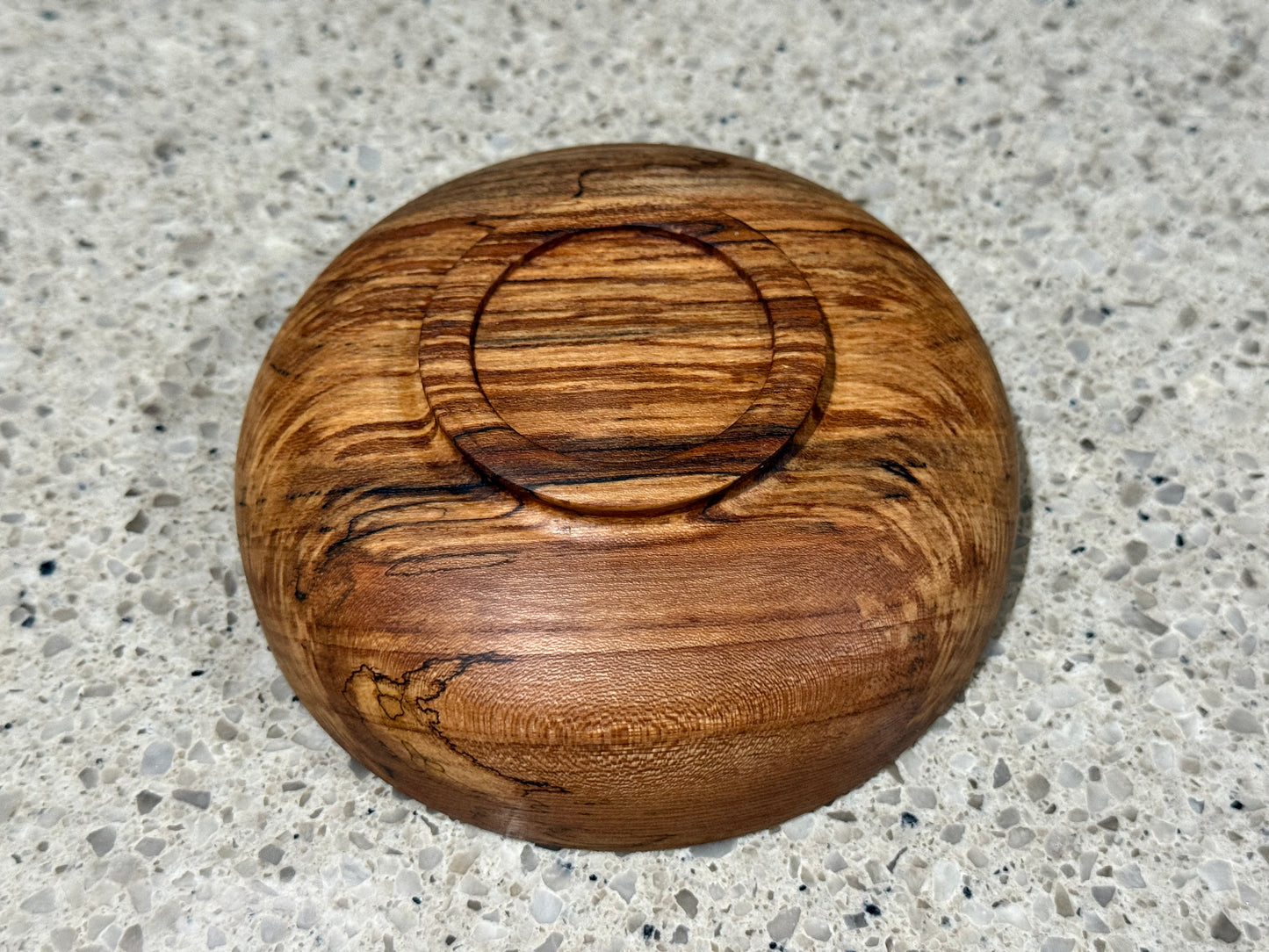 Wooden bowl on a kitchen counter with a tiled wall background
