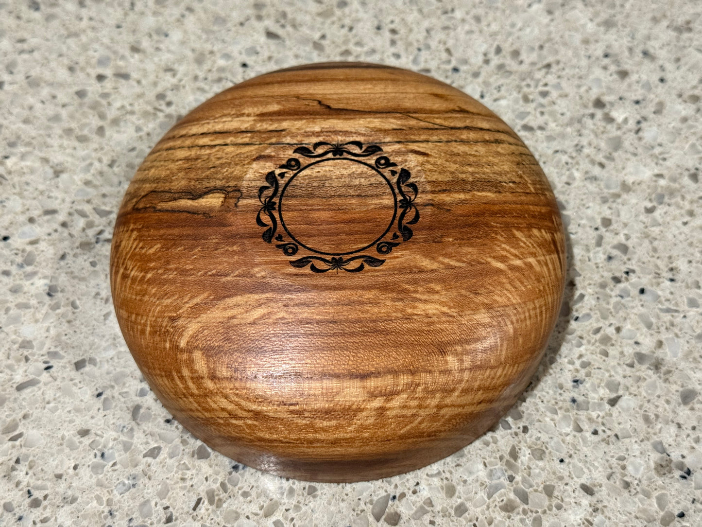 Wooden bowl on a kitchen counter with a tiled wall background
