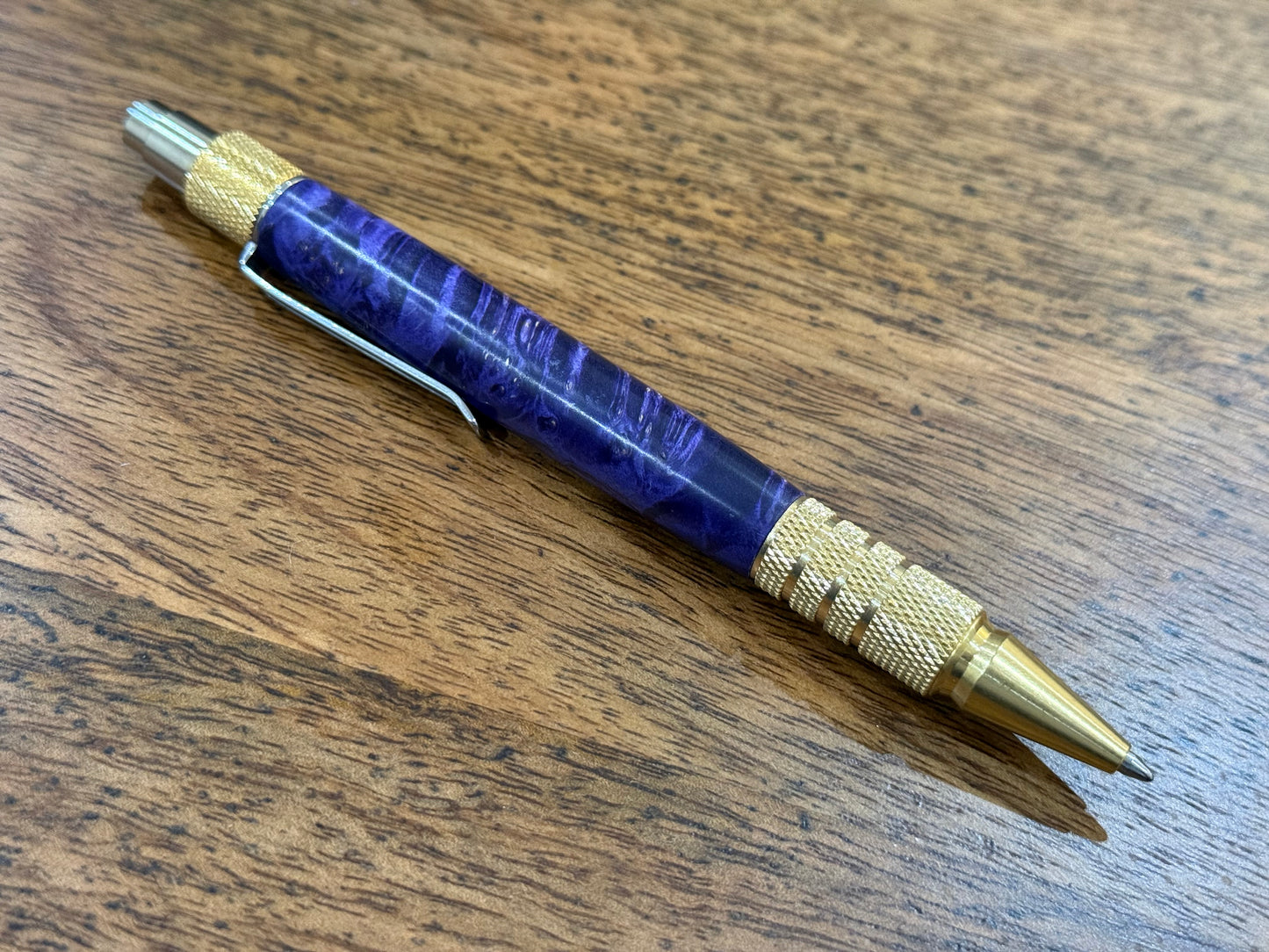 Pen with blue barrel and gold accents on a wooden surface