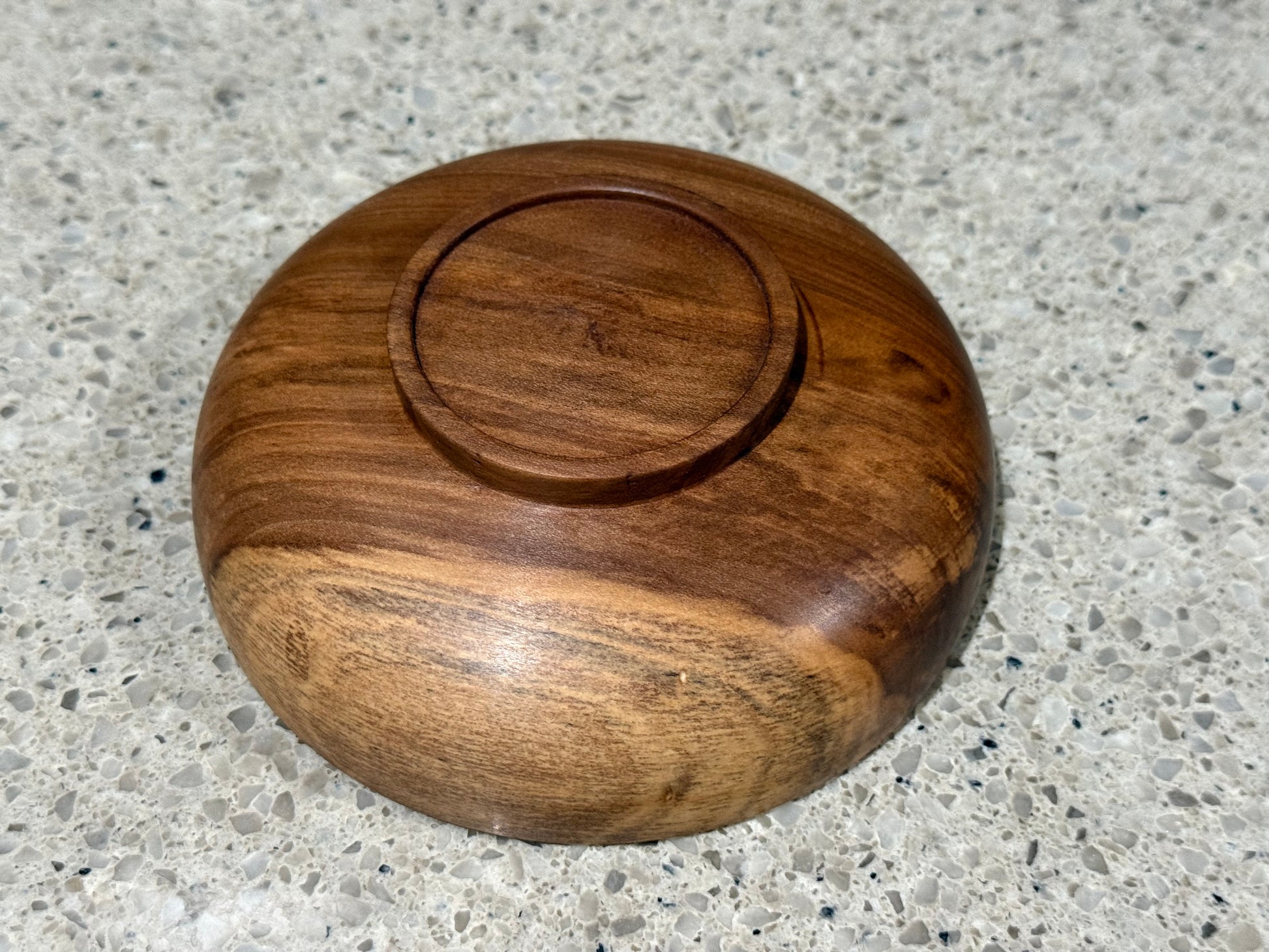 Wooden bowl with a lid on a gray concrete surface