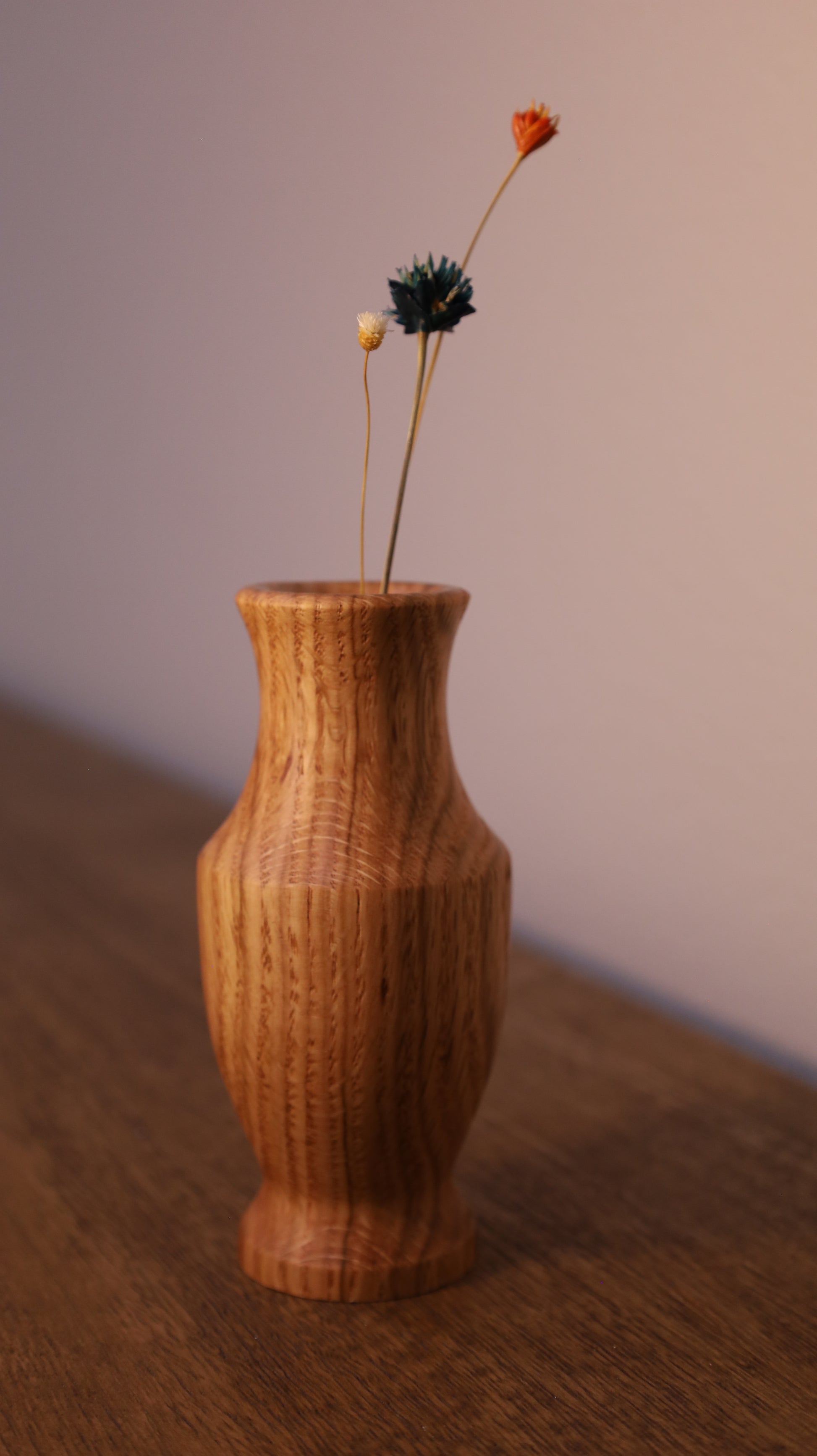 Wooden vase with a dried flower on a gradient background