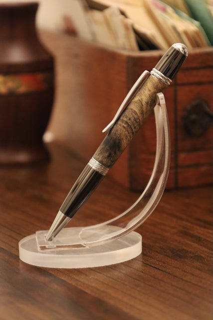 custom Pen on a clear stand with a wooden and metal design, placed on a wooden surface.