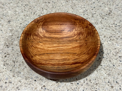 Wooden bowl on a kitchen counter with a tiled wall background