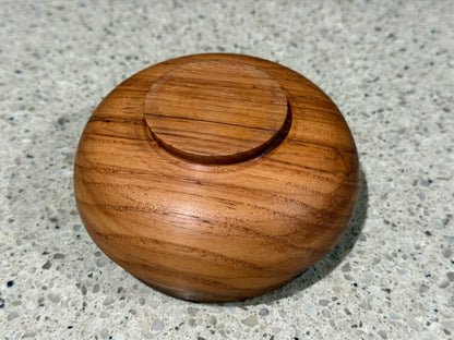 Wooden container lid on a speckled gray surface