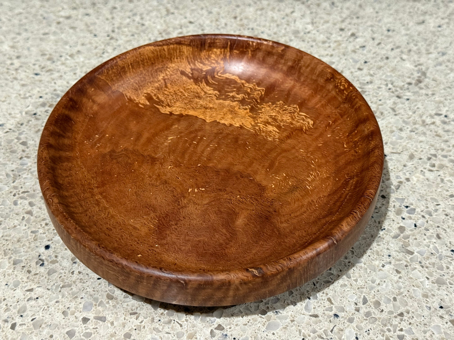 Wooden bowl on a kitchen counter with a tiled wall background