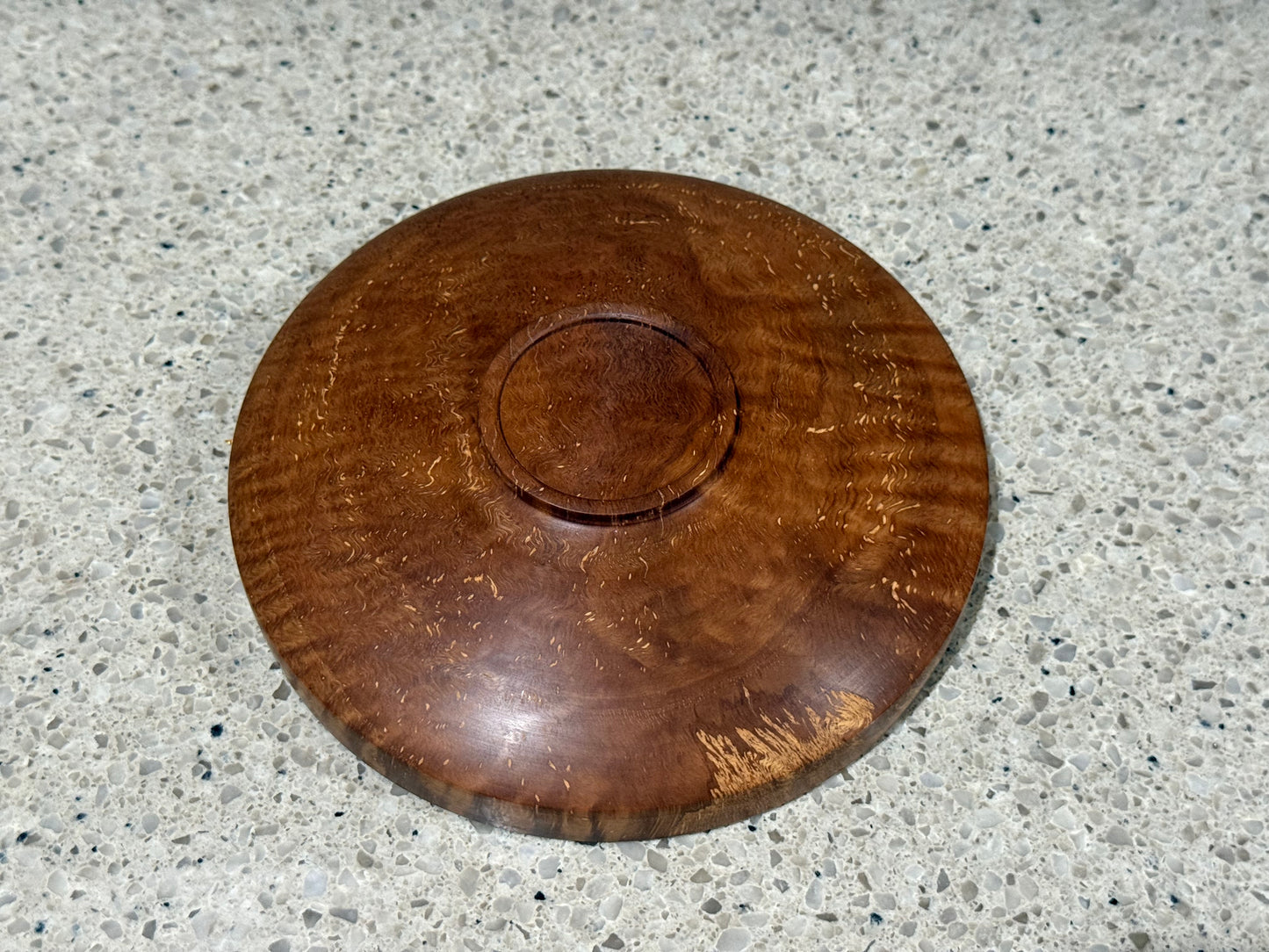 Wooden bowl on a kitchen counter with a tiled wall background