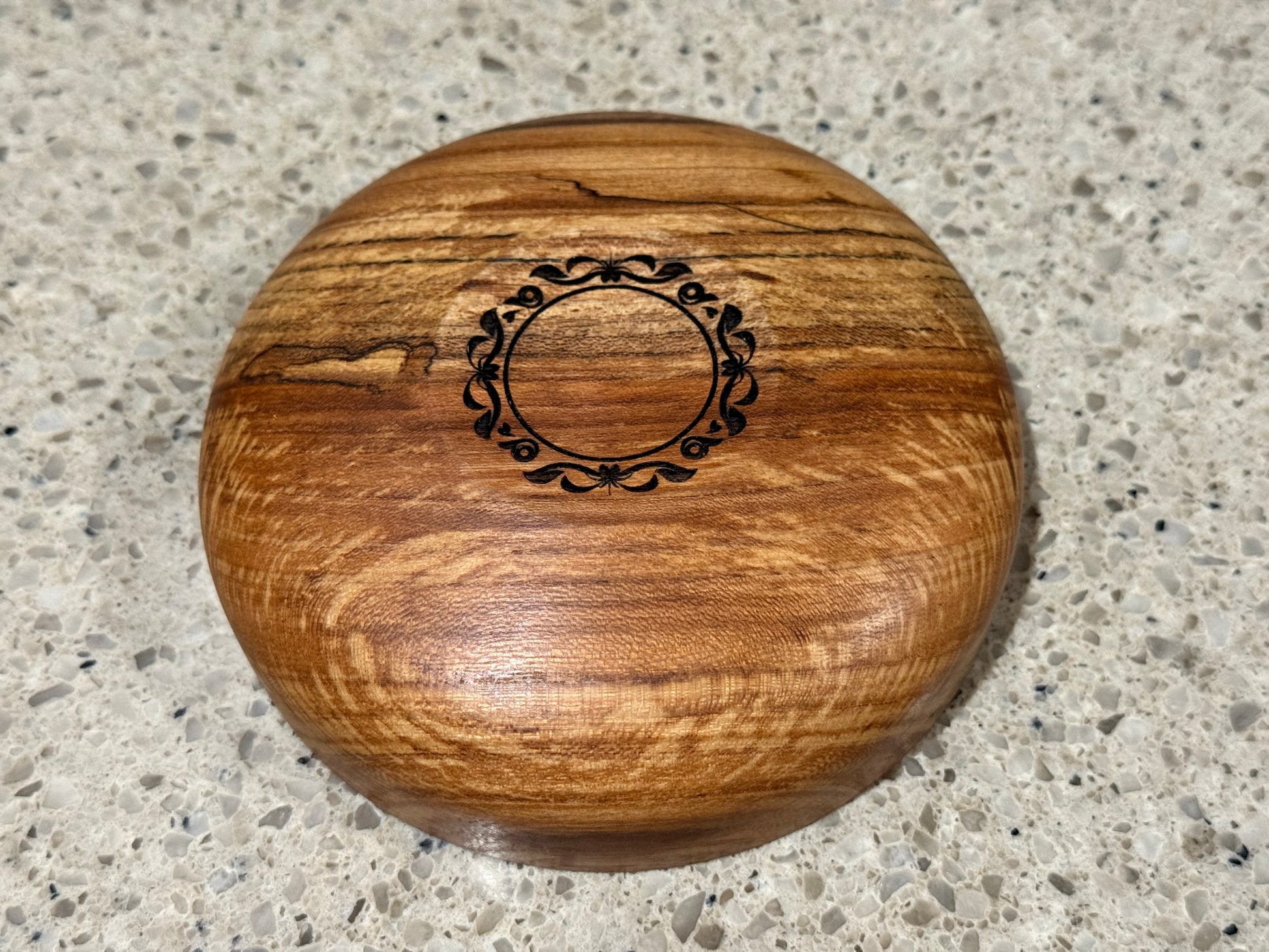Wooden bowl on a kitchen counter with a tiled wall background