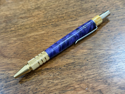 Pen with purple and gold design on a wooden surface